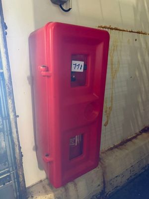 une borne d'incendie rouge au coin d'un immeuble