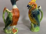 two ceramic birds that are sitting on a pitcher