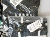 many bags of clothing that are sitting on a table