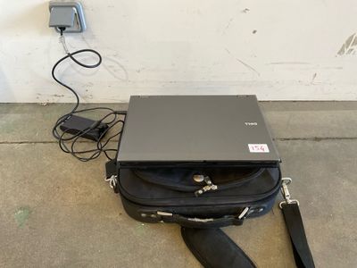 a laptop sitting on the ground next to a black bag