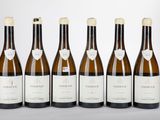 six bouteilles de vin sont alignées sur une table