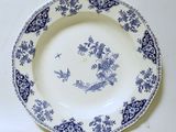 une assiette bleue et blanche ornée d'un oiseau et de fleurs