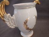 a white and gold vase with wings on it