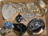 une boîte en carton remplie de figurines en verre et d'autres objets