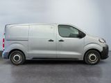 the silver van is parked in a room with a gray wall