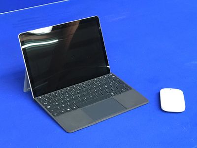 un ordinateur portable et une souris posés sur une surface bleue