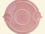 a pink plate with a flower decoration on it