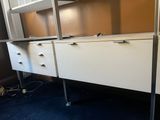 an image of a white desk with drawers and cabinets