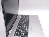a silver laptop with a black keyboard on a white surface