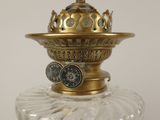 a glass vase with a gold lid and a clock on it