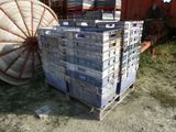une grande pile de cartons posée sur une palette à côté d'un gros objet