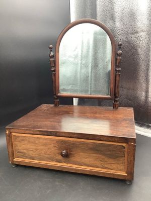 une photo d'une petite coiffeuse en bois surmontée d'un miroir