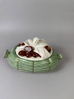 a ceramic bowl with cherries in it on a table