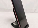 a close up of a cell phone on a stand on a white surface