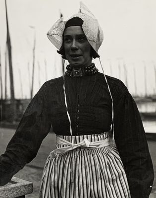 une vieille photo en noir et blanc représentant une femme en robe et chapeau