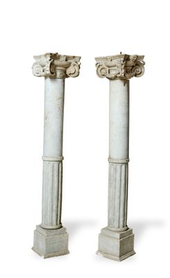 pair of white marble pedestals with columns on top of them
