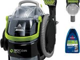 un gros plan sur un aspirateur vert et noir et un flacon de produit nettoyant