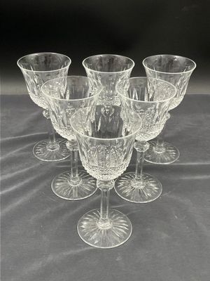 six verres à vin transparents posés les uns à côté des autres sur une table