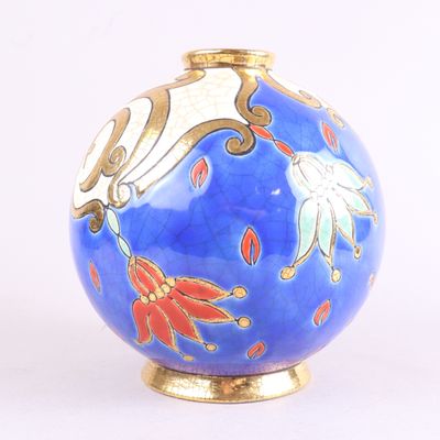 un vase bleu orné de fleurs dorées et rouges
