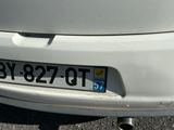 a close up of a white car with a license plate on it