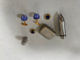a silver lighter, cufflinks, and a lighter on a table