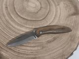 a knife that is sitting on top of a piece of wood