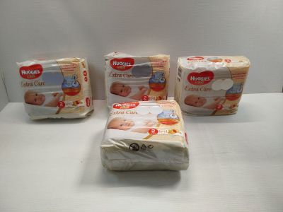 three packs of baby diapers sitting on top of a white table