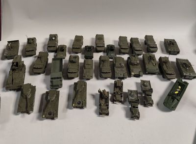 tout un tas de petits véhicules militaires miniatures posés sur une table