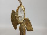 brass figurine of a woman holding a fan and a crystal