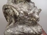 statue of a man with a gun on a rock with a red marble base