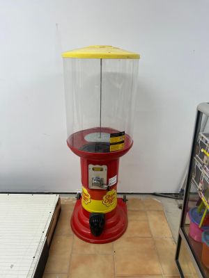 une machine rouge et jaune posée sur un sol carrelé
