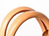 the handle of a brown purse with two handles on a white surface