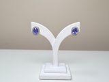 paire de boucles d'oreilles en saphir bleu et diamants, présentées sur un socle blanc