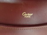 the back of a brown leather bag with a gold logo on it