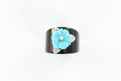 un gros plan d'une bague ornée d'une fleur