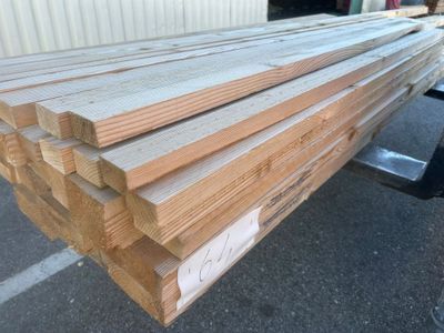 plusieurs morceaux de bois empilés les uns sur les autres devant un bâtiment