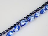 two strands of blue and black glass beads on a white surface