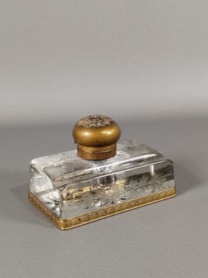 une petite bouteille en verre avec un bouchon doré posée sur une table