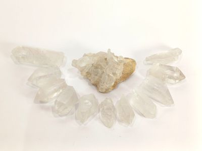 un amas de cristaux sur fond blanc, avec au centre un morceau de roche en forme de cœur