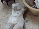 un bol rempli de coquillages et un ours en peluche posé par terre