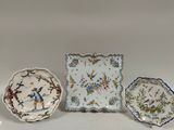trois petites assiettes ornées d'oiseaux et de fleurs, posées sur une table
