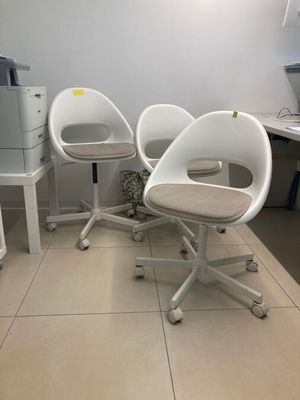 trois chaises blanches dans une pièce où se trouve une imprimante
