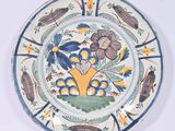 une assiette ornée d'un motif représentant des fleurs et des insectes