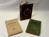three books that are sitting on a white surface