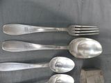 five silver spoons and two silver spoons on a table