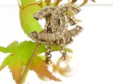 a pearl and diamond brooch on a tree branch