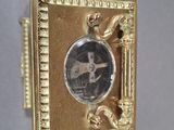 a gold frame with a picture of a man in a hat