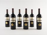 six bottles of wine are lined up on a white surface