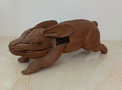 a wooden sculpture of a dog that is sitting on a table