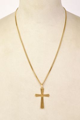 a gold cross pendant on a mannequin torso